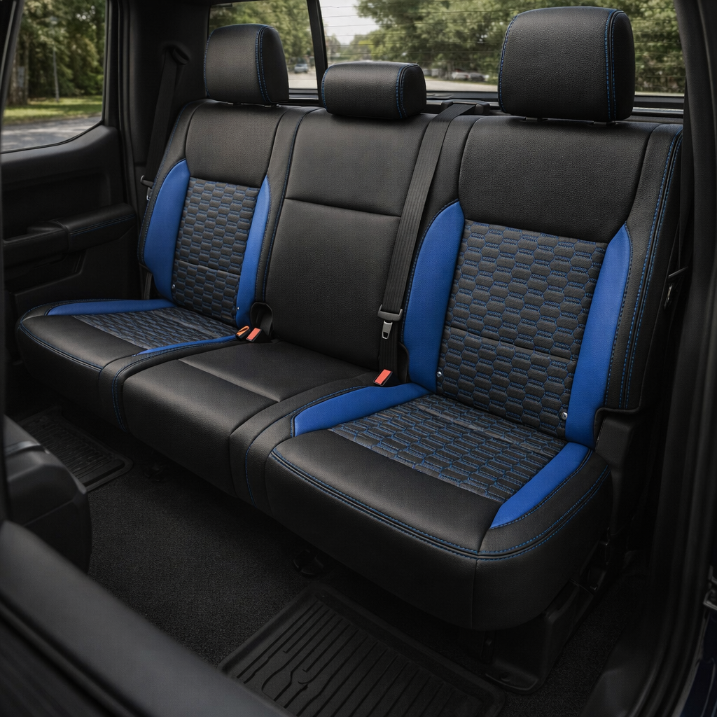 Rear in-cabin view of a 2021–2026 Ford F-150 XLT showing Leatherteck rear bench seat covers in black with Bermuda Blue Double Hex pattern center inserts, Bermuda Blue accent panels, and Bermuda Blue contrast stitching, with three headrests, seatbelts/buckles, and the rear window visible behind the seat.